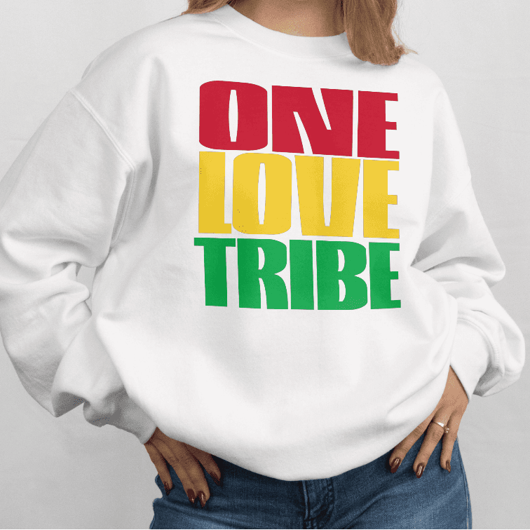 Person wearing a white sweatshirt with 'ONE LOVE TRIBE' text in red, yellow, and green on a plain background
