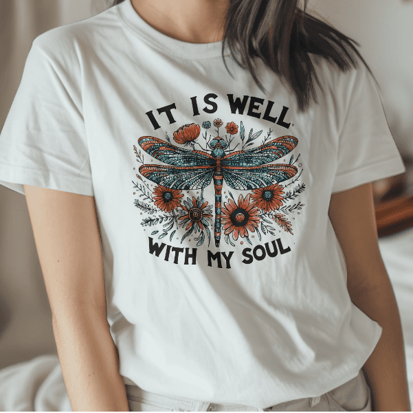Woman wearing a white t-shirt with a dragonfly design and text in a casual setting.