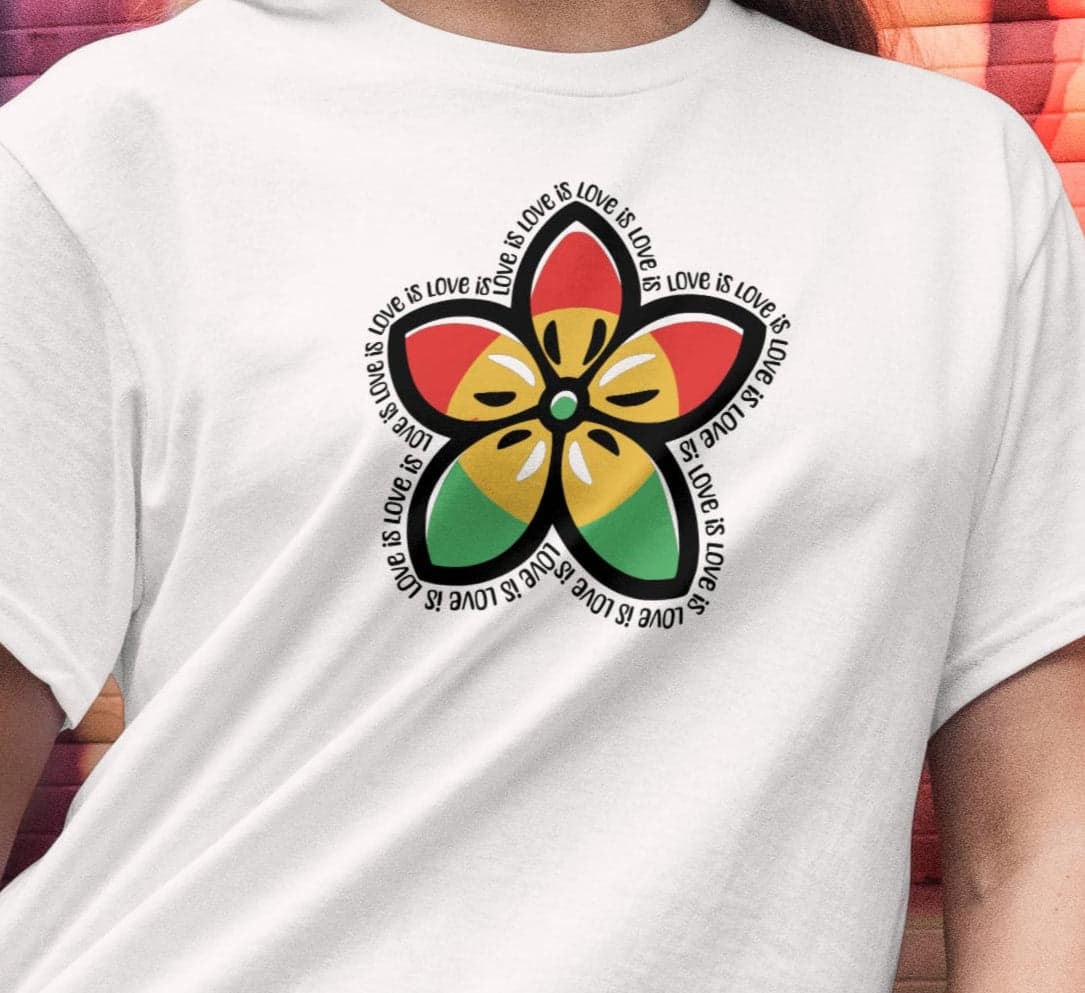 Person wearing a white t-shirt with a colorful flower design in front of a vibrant graffiti wall.